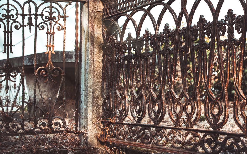 Weathered iron fence with decorative detail.