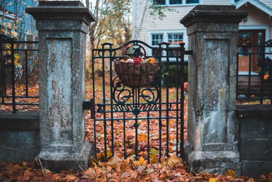 Stone gate pillars with an iron gate leading to a home.