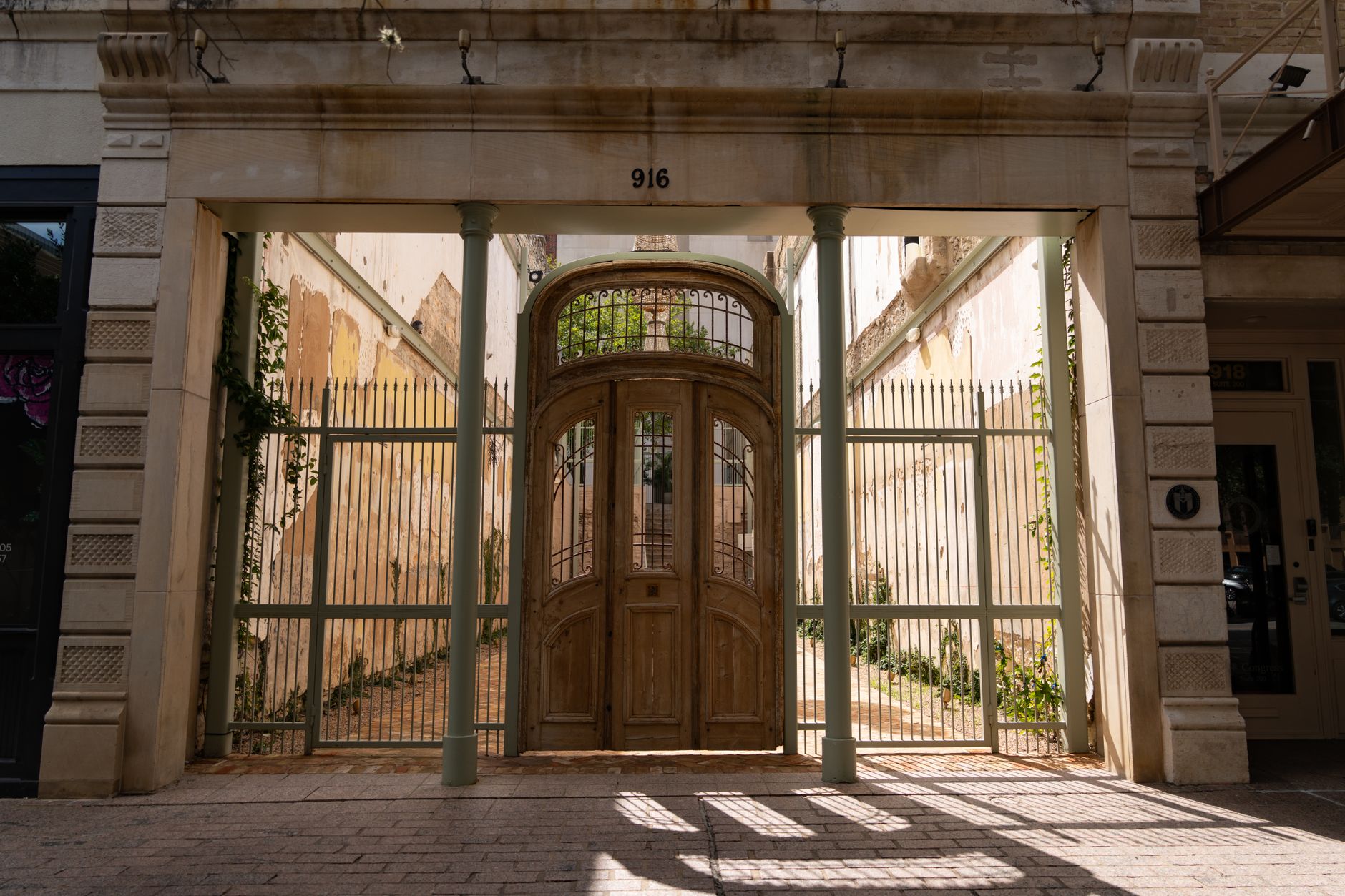 An ornate wooden gate framed by tall columns in downtown Austin, Texas